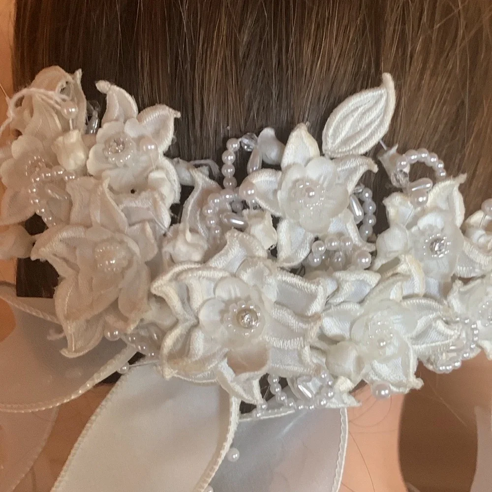White floral and satin ribbon hairpiece with pearl and rhinestone detail